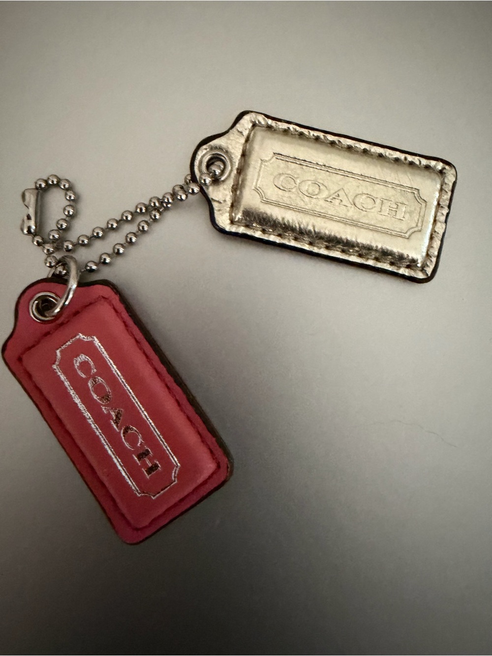 COACH Two hang tags. One gold metallic and one pink with silver